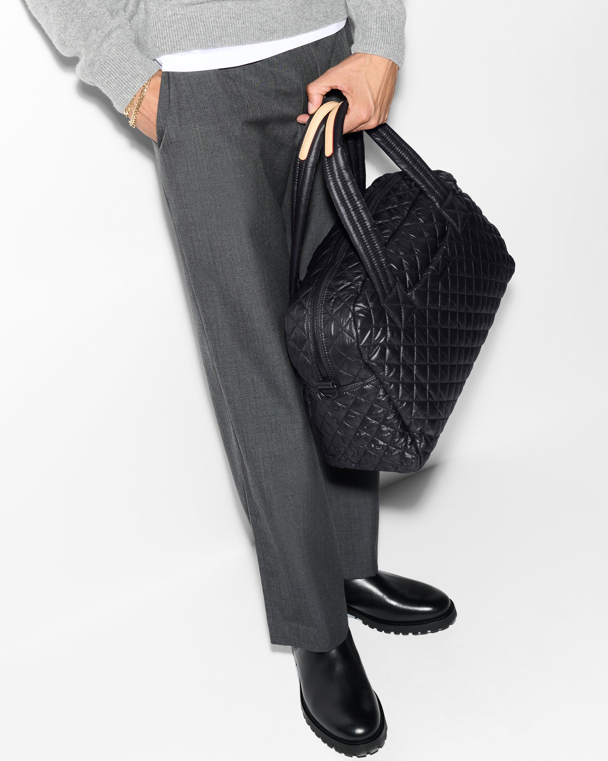 Man holding MZ Wallace Black Quilted Duffle Travel Bag