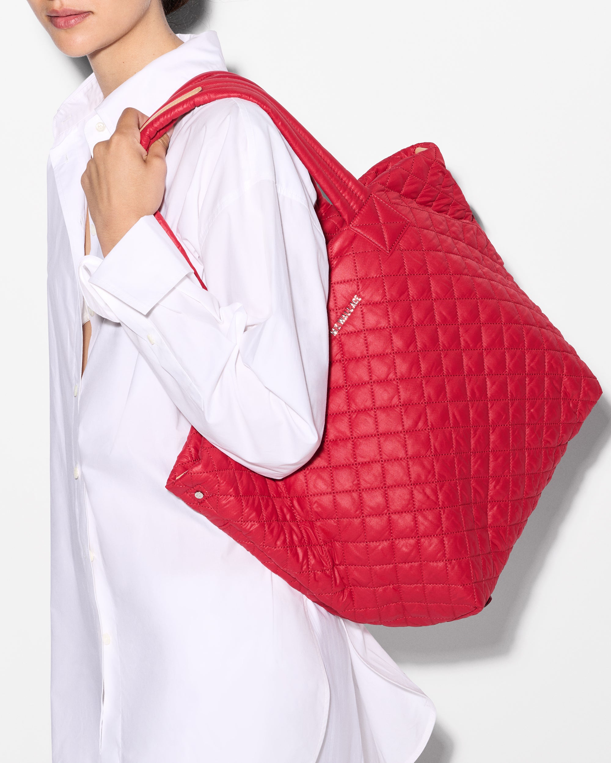 Woman holding MZ Wallace Bright Red Tote Bag on shoulder