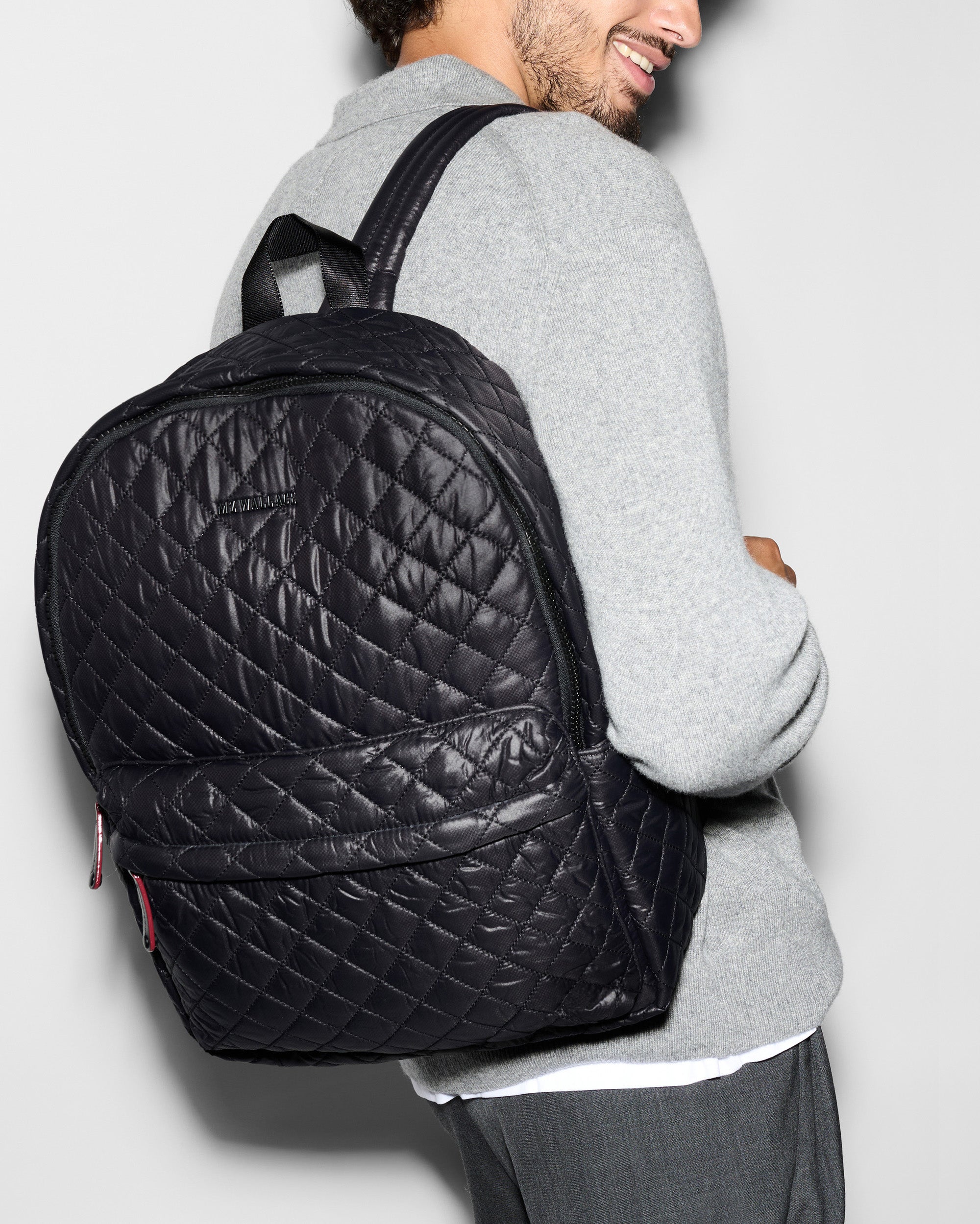 Man wearing Metro Quilted Backpack Deluxe - Lightweight Black Quilted Backpack