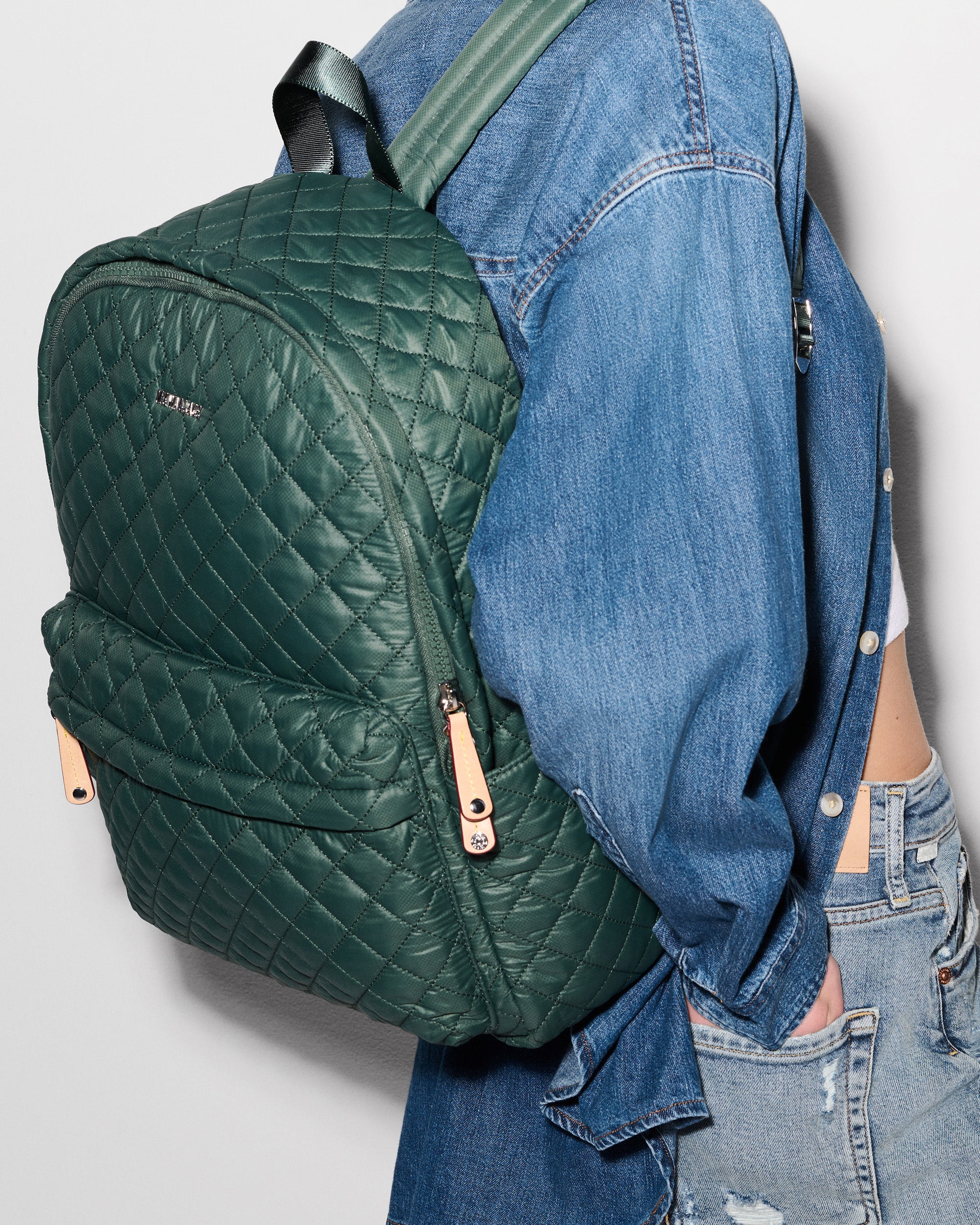 Woman wearing MZ Wallace Green Quilted Backpack on back