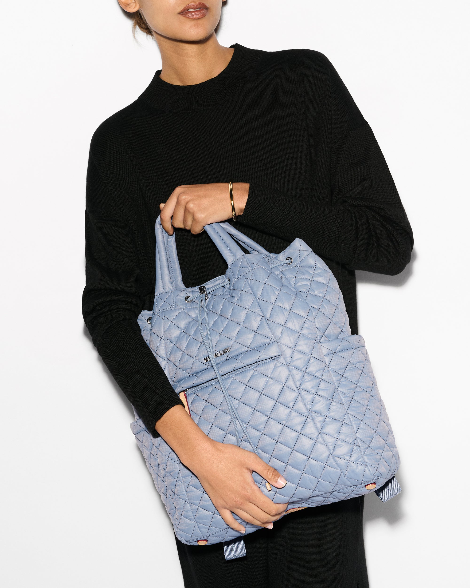 Woman holding MZ Wallace Light Blue Convertible Backpack Purse