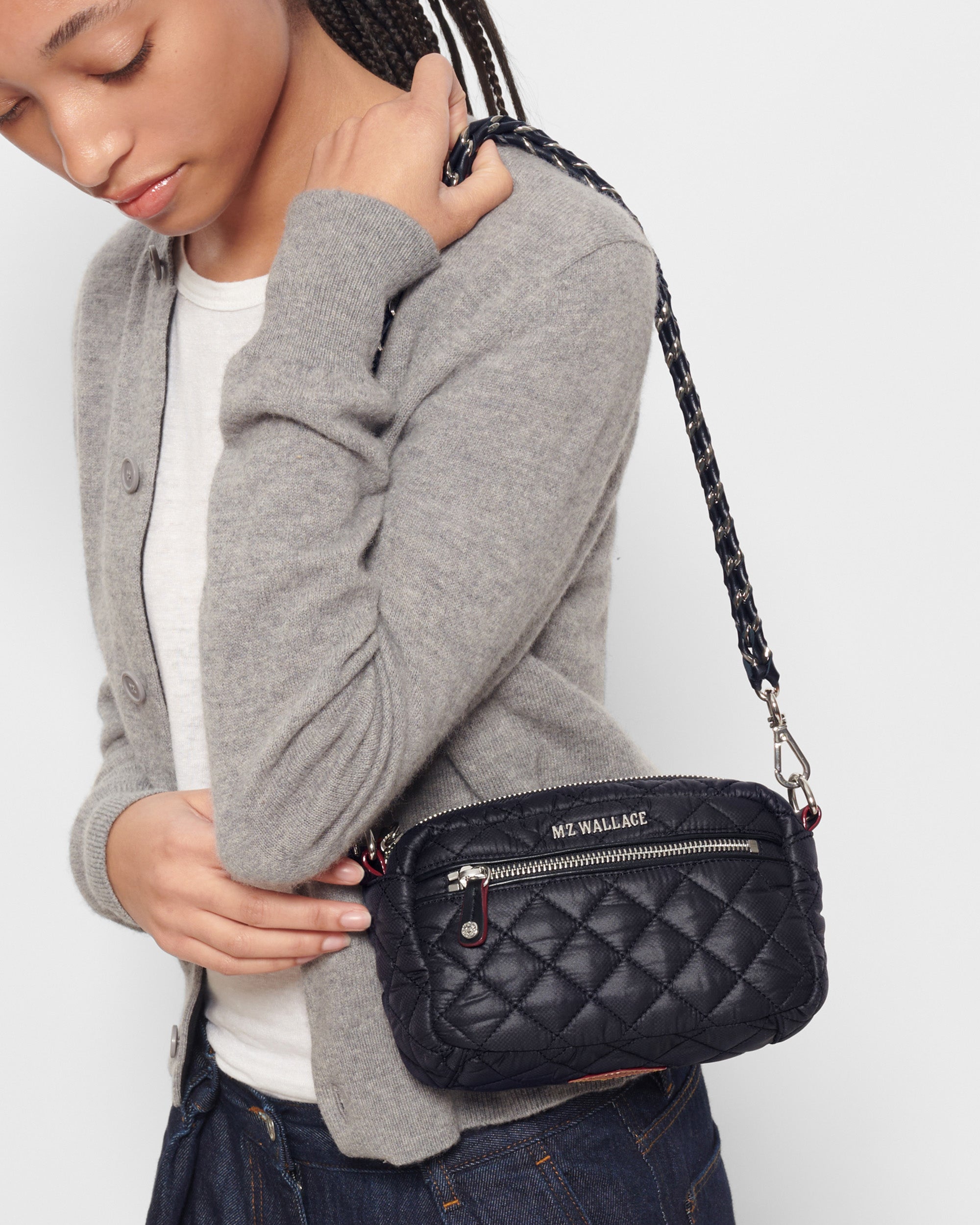 Woman holding MZ Wallace Black Quilted Crossbody Bag with strap