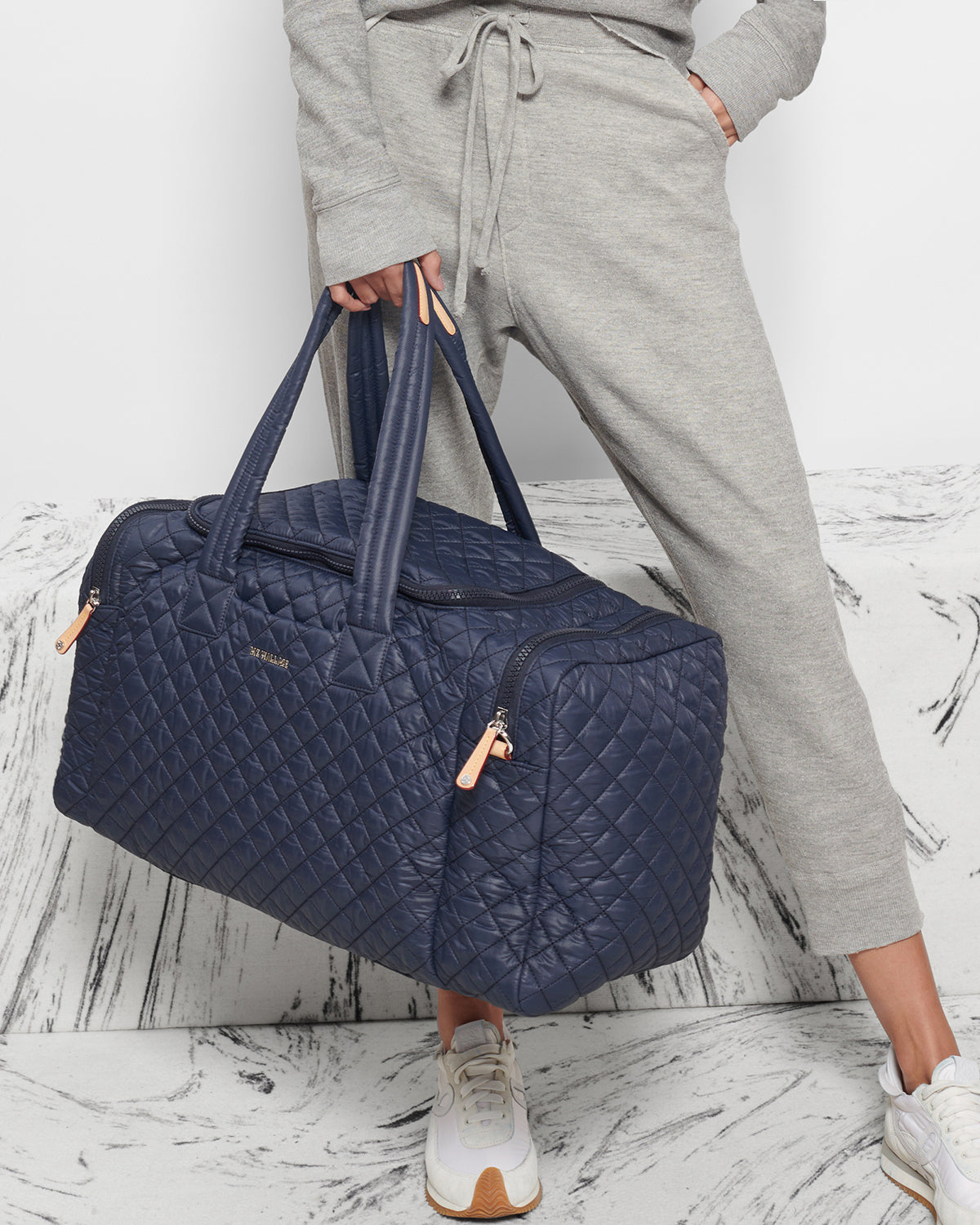 Woman holding MZ Wallace Navy Blue Overnight Bag in hand