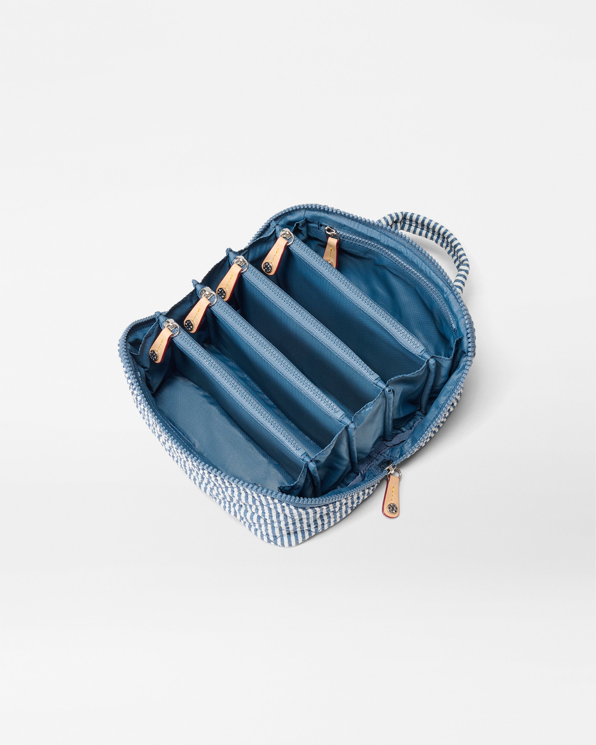 Different pockets of the MZ Wallace Seersucker Blue and White Makeup Bag