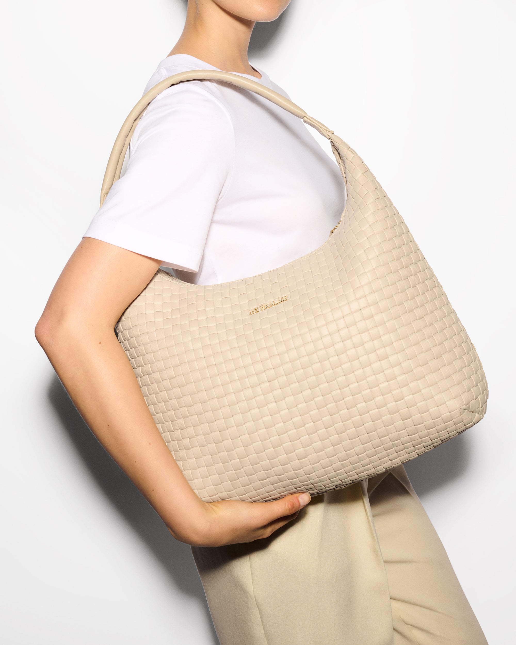 Woman holding MZ Wallace Cream Woven Bag on shoulder