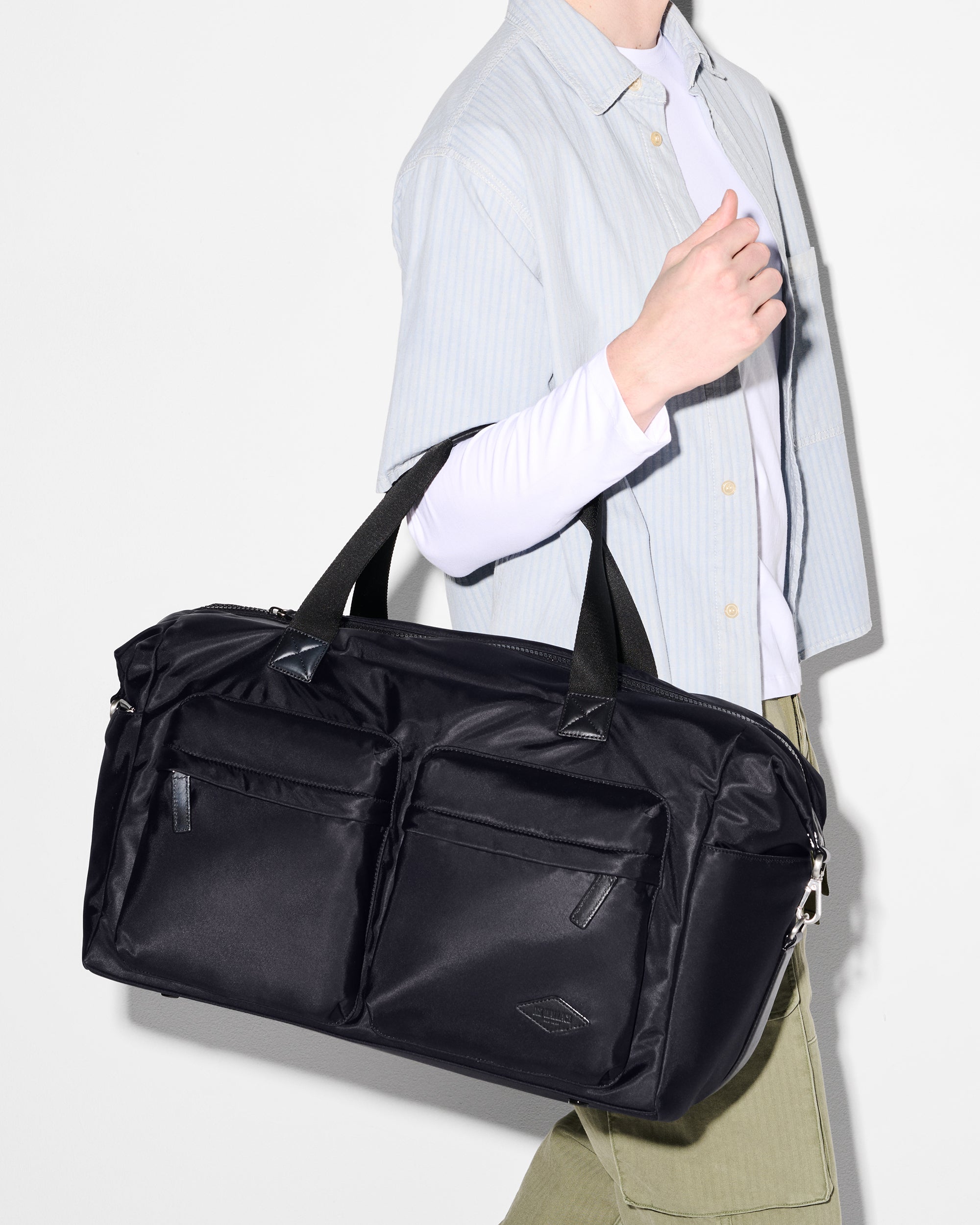 Model Holding Large Black Duffle Bag