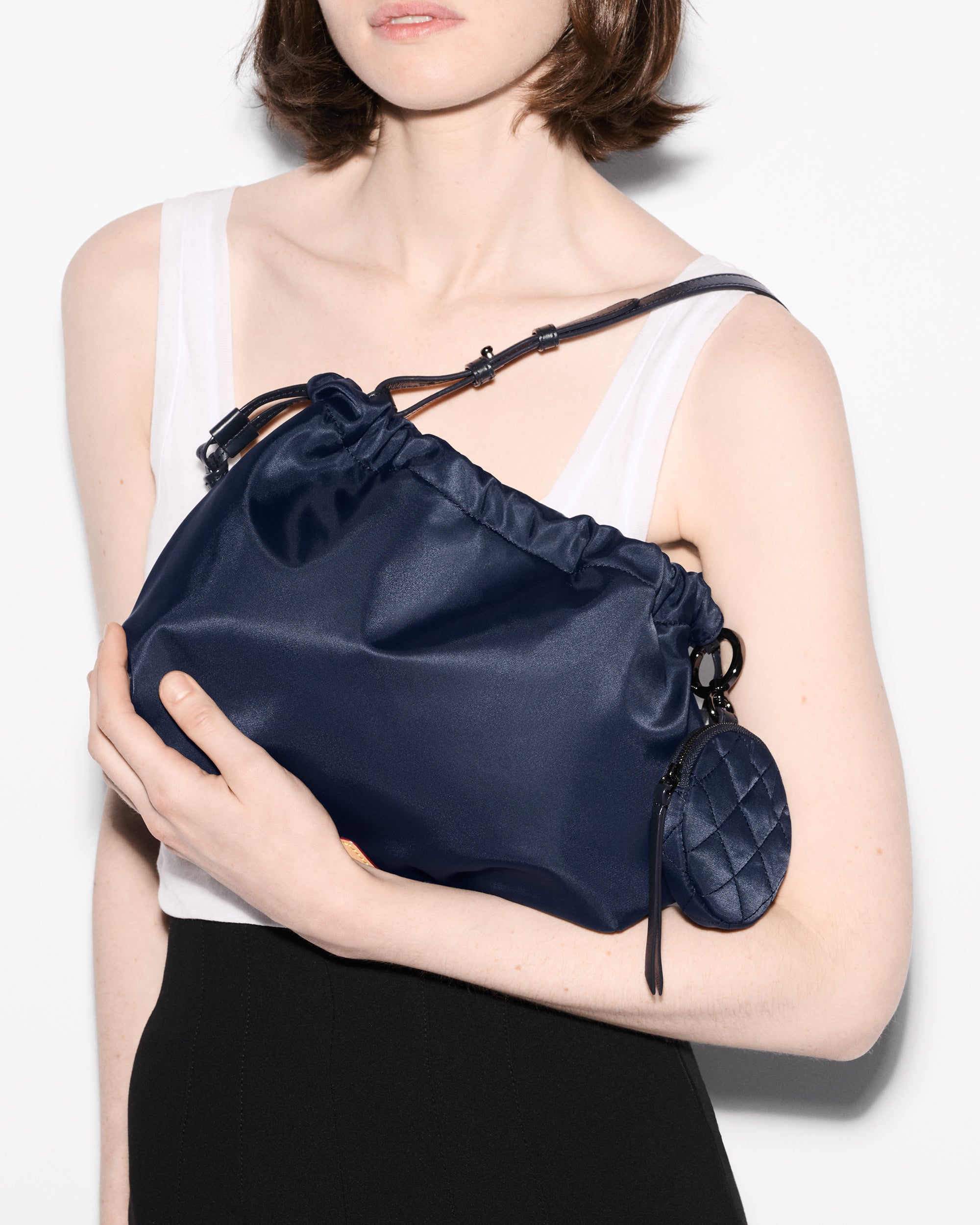 Woman holding MZ Wallace Blue Shoulder Bag close to chest