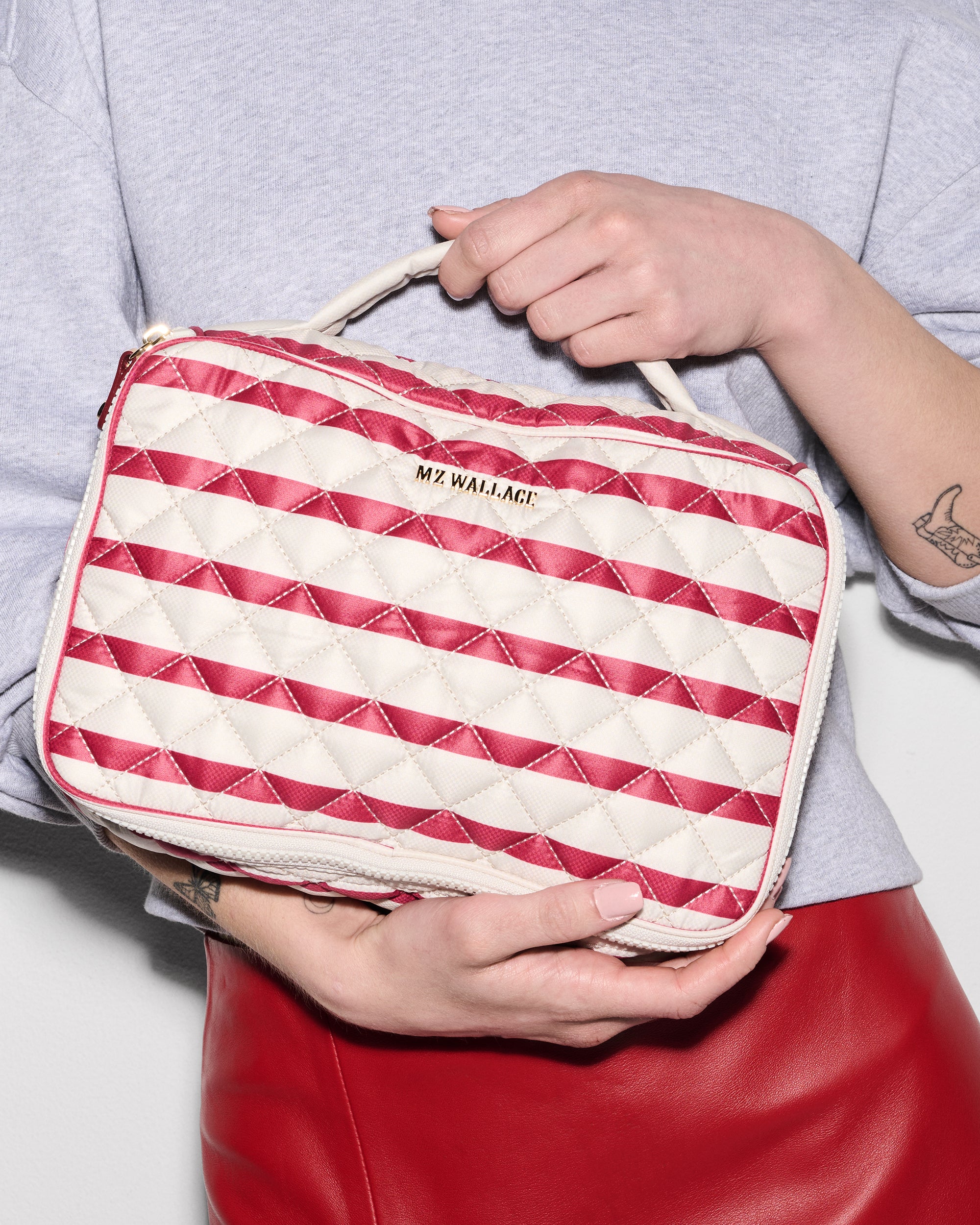 Woman holding MZ Wallace Red and White Striped Makeup Bag