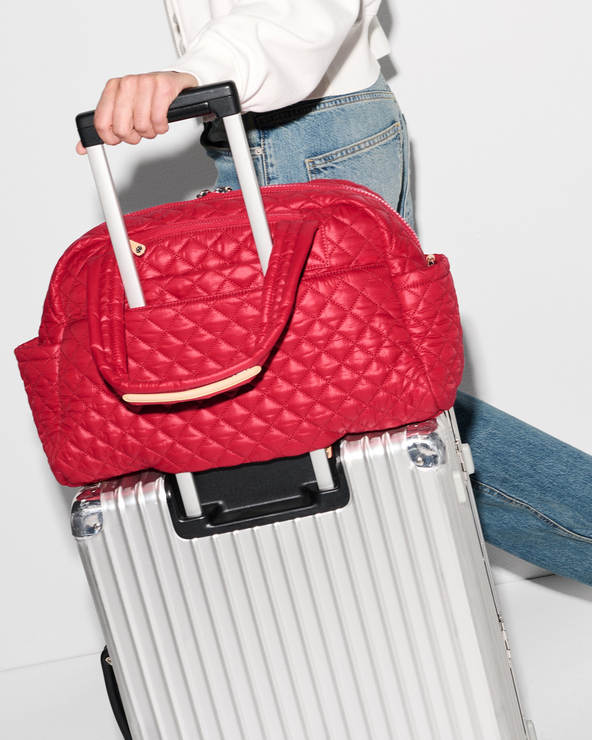 MZ Wallace Red Duffel Bag attached to suitcase