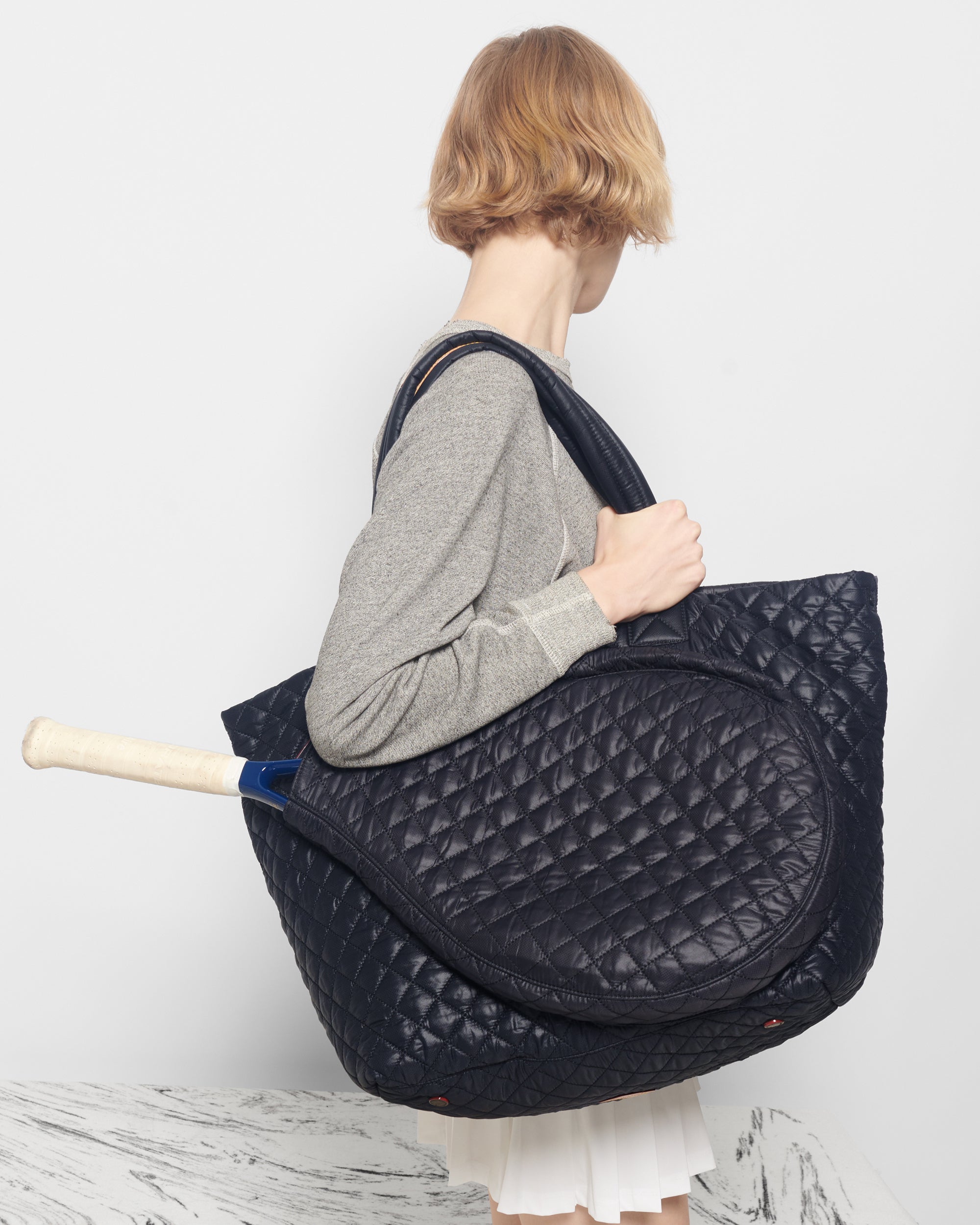 Woman holding MZ Wallace Quilted Large Black Tennis Bag 